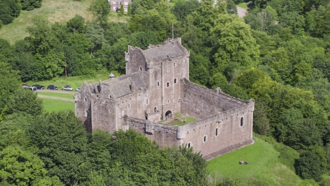AX109_071.0000000F - Aerial stock photo of Doune Castle with tourists on the grounds, Scotland