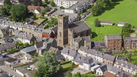 AX109_073.0000000F - Aerial stock photo of A church in a residential area, Doune Scotland