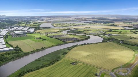 AX109_102.0000000F - Aerial stock photo of The River Forth near warehouses and green farm fields in Fallin, Scotland