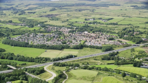 AX109_172.0000093F - Aerial stock photo of Farm fields and highway M80 by rural village homes, Bonnybridge, Scotland