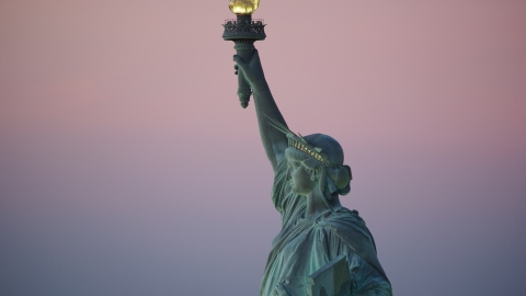 AX118_060.0000227F - Aerial stock photo of The Statue of Liberty's profile at sunrise, New York