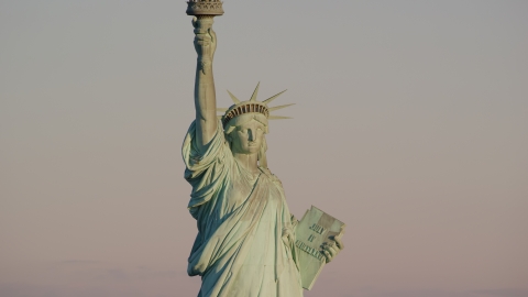 AX118_107.0000082F - Aerial stock photo of The front of the Statue of Liberty at sunrise in New York