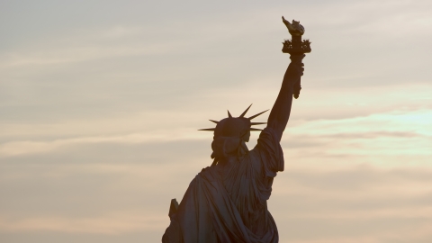 AX118_111.0000000F - Aerial stock photo of Back of the Statue of Liberty at sunrise in New York