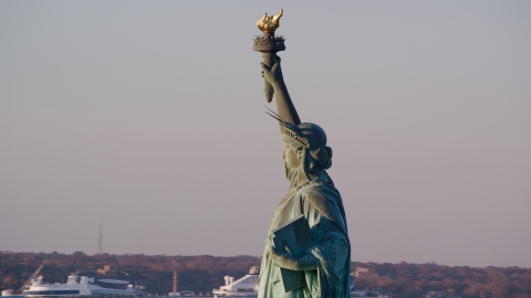 AX118_114.0000066F - Aerial stock photo of Left side profile of the Statue of Liberty at sunrise in New York