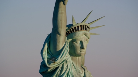 AX118_117.0000113F - Aerial stock photo of Close-up profile of the Statue of Liberty at sunrise in New York