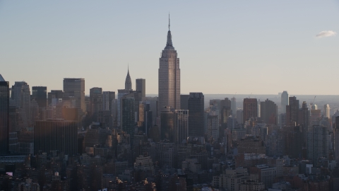 AX118_162.0000089F - Aerial stock photo of Empire State Building at sunrise in New York City