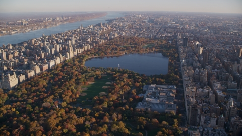 AX118_192.0000000F - Aerial stock photo of Central Park with autumn leaves and The Met at sunrise in New York City