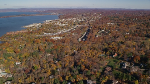 AX119_112.0000105F - Aerial stock photo of Upscale homes and small riverfront towns in autumn, Briarcliff Manor and Ossining, New York