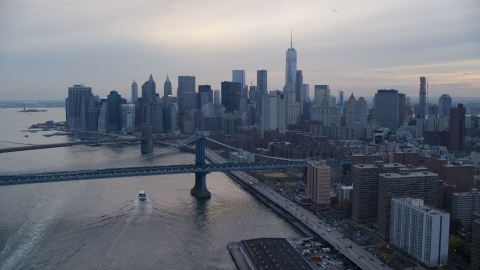 AX121_028.0000216F - Aerial stock photo of The Manhattan Bridge near the Lower Manhattan skyline at sunset in New York City