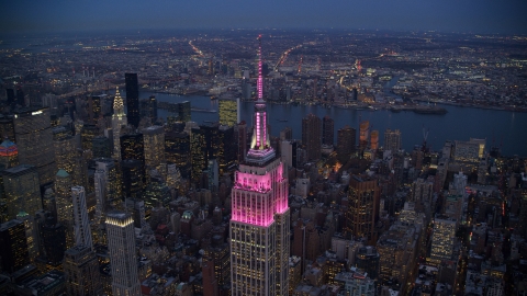 AX121_108.0000414F - Aerial stock photo of The Empire State Building with pink lights at sunset in Midtown, New York City