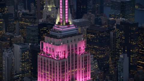AX121_109.0000095F - Aerial stock photo of Empire State Building with pink lighting at sunset in Midtown Manhattan, New York City