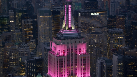 AX121_109.0000359F - Aerial stock photo of Pink lights on the Empire State Building at sunset in Midtown Manhattan, New York City