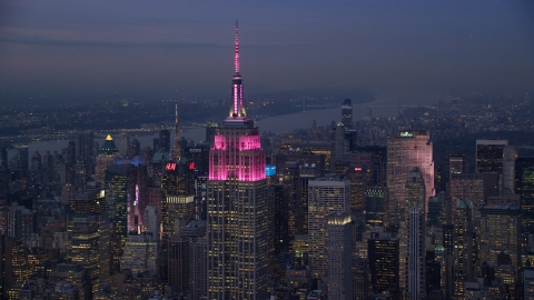 AX121_111.0000100F - Aerial stock photo of Pink lights on the Empire State Building at sunset in Midtown Manhattan, New York City