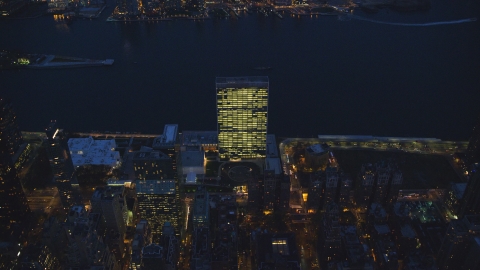 AX121_138.0000309F - Aerial stock photo of The United Nations by the East River at night in Midtown Manhattan, New York City