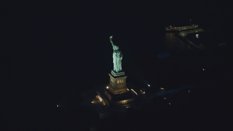 AX121_167.0000184F - Aerial stock photo of The Statue of Liberty at night in New York