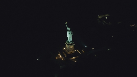 AX121_195.0000063F - Aerial stock photo of The Statue of Liberty at night, New York
