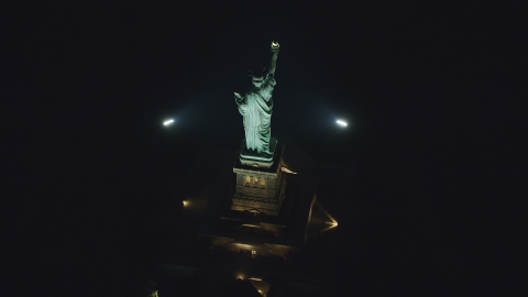 AX121_196.0000217F - Aerial stock photo of A bird's eye of the Statue of Liberty at nighttime in New York