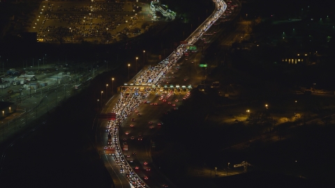 AX121_199.0000070F - Aerial stock photo of Heavy traffic at a Jersey City toll station at night, New Jersey