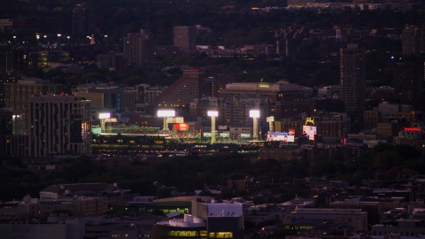 AX141_014.0000174 - Aerial stock photo of Bright lights and a baseball game at Fenway Park, Boston, Massachusetts, twilight