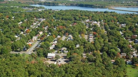 AX143_004.0000035 - Aerial stock photo of Small town neighborhoods and trees in autumn, Randolph, Massachusetts