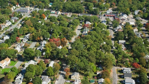 AX143_005.0000000 - Aerial stock photo of Small town neighborhood, trees in autumn, Randolph, Massachusetts