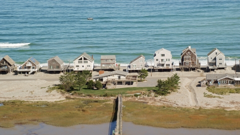 AX143_049.0000327 - Aerial stock photo of Several elevated oceanfront homes in Humarock, Massachusetts