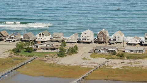 AX143_049.0000422 - Aerial stock photo of Elevated homes by the ocean, Humarock, Massachusetts
