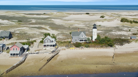 AX143_144.0000125 - Aerial stock photo of Sandy Neck Colony houses by Sandy Neck Light on Cape Cod, Barnstable, Massachusetts