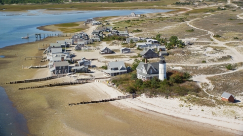 AX143_145.0000207 - Aerial stock photo of Beachfront houses at Sandy Neck Colony by Sandy Neck Light, Cape Cod, Barnstable, Massachusetts