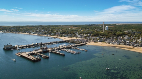 AX143_231.0000282 - Aerial stock photo of A small coastal town seen from near piers in the bay, Provincetown, Massachusetts