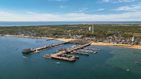 AX143_232.0000117 - Aerial stock photo of Piers and a small coastal town seen from the bay, Provincetown, Massachusetts