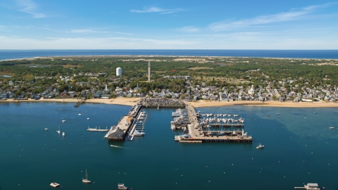 AX143_233.0000122 - Aerial stock photo of Boats docked at piers by a small coastal town, Cape Cod, Provincetown, Massachusetts