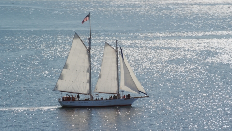 AX143_243.0000106 - Aerial stock photo of A sailing boat with a crowd of people on Cape Cod Bay, Massachusetts