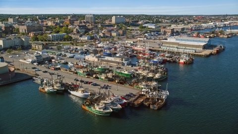 AX144_194.0000003 - Aerial stock photo of Fishing boats docked at piers in New Bedford, Massachusetts