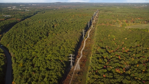AX145_125.0000000 - Aerial stock photo of Power lines through deciduous forest in autumn, Walpole, Massachusetts