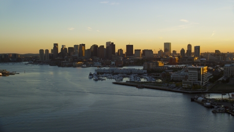 AX146_076.0000282F - Aerial stock photo of The city skyline of Downtown Boston seen from the Charles River, Massachusetts, sunset
