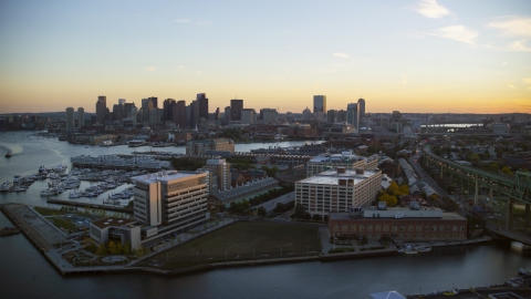 AX146_097.0000237F - Aerial stock photo of Office buildings in Charlestown, Massachusetts at sunset, and the Downtown Boston skyline
