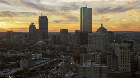AX146_113.0000175F - Aerial stock photo of Towering city skyscrapers in Downtown Boston, Massachusetts, sunset