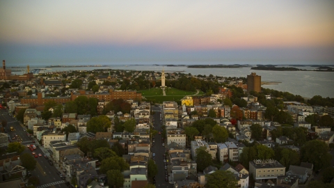AX146_116.0000187F - Aerial stock photo of A view of of Dorchester Heights Monument and row houses in South Boston, Massachusetts, twilight