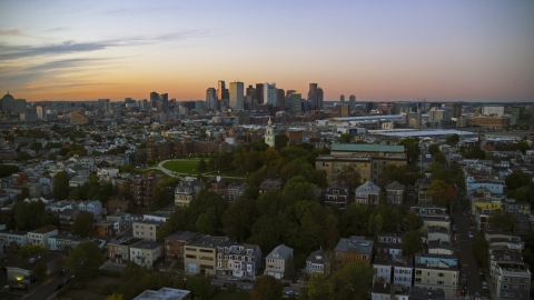 AX146_120.0000325F - Aerial stock photo of Dorchester Heights Monument in South Boston at twilight and the Downtown Boston skyline, Massachusetts