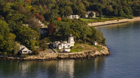 AX147_053.0000174 - Aerial stock photo of Hospital Point Light beside a cove, autumn, Beverly, Massachusetts