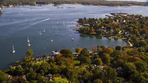 AX147_189.0000357 - Aerial stock photo of Coastal homes near sailboats in autumn, New Castle, New Hampshire