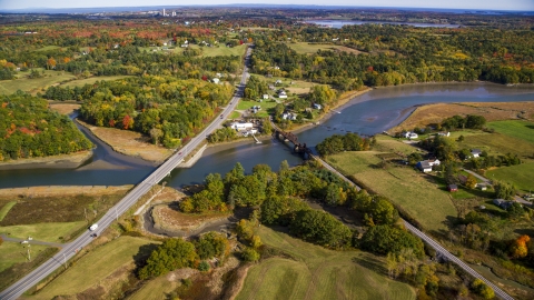 AX148_067.0000079 - Aerial stock photo of Small bridges, Highway 1 over river near rural homes, autumn, Thomaston, Maine