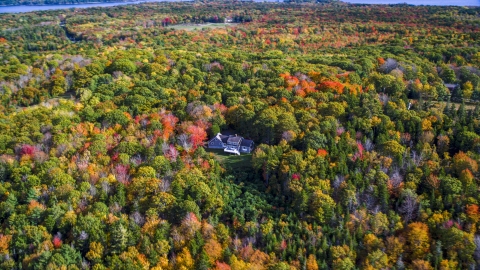 AX148_079.0000017 - Aerial stock photo of A lone rural home and a colorful forest, autumn, Owls Head, Maine