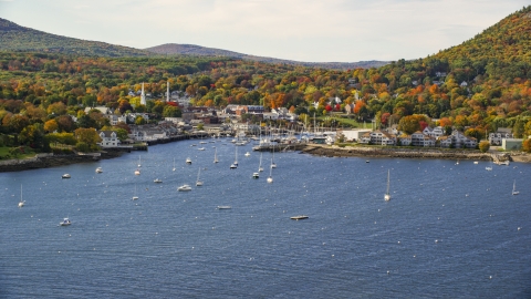 AX148_110.0000267 - Aerial stock photo of Camden Harbor and the small coastal town in autumn, Camden, Maine