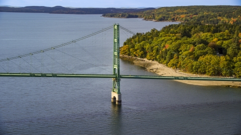 AX148_141.0000000 - Aerial stock photo of The Deer Isle Bridge near dense trees in autumn, Deer Isle Bridge, Maine