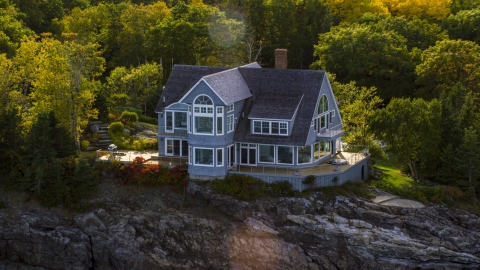 AX148_184.0000221 - Aerial stock photo of A mansion on a rocky shore in autumn, Bar Harbor, Maine