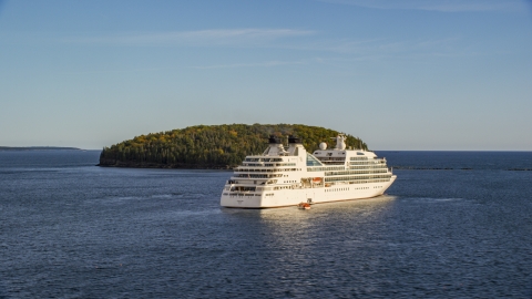 AX148_200.0000250 - Aerial stock photo of A cruise ship sailing past a tiny island, Bar Harbor, Maine