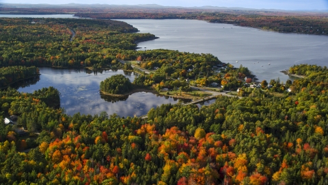 AX148_230.0000028 - Aerial stock photo of Fall foliage around a pond and coastal town, Bar Harbor, Maine