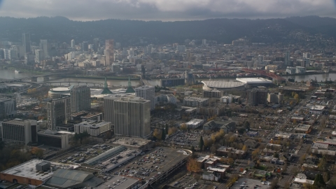 AX153_111.0000319F - Aerial stock photo of Downtown Portland behind office buildings and Moda Center, Oregon 